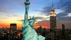 The Statue of Liberty and New York City skyline at dark